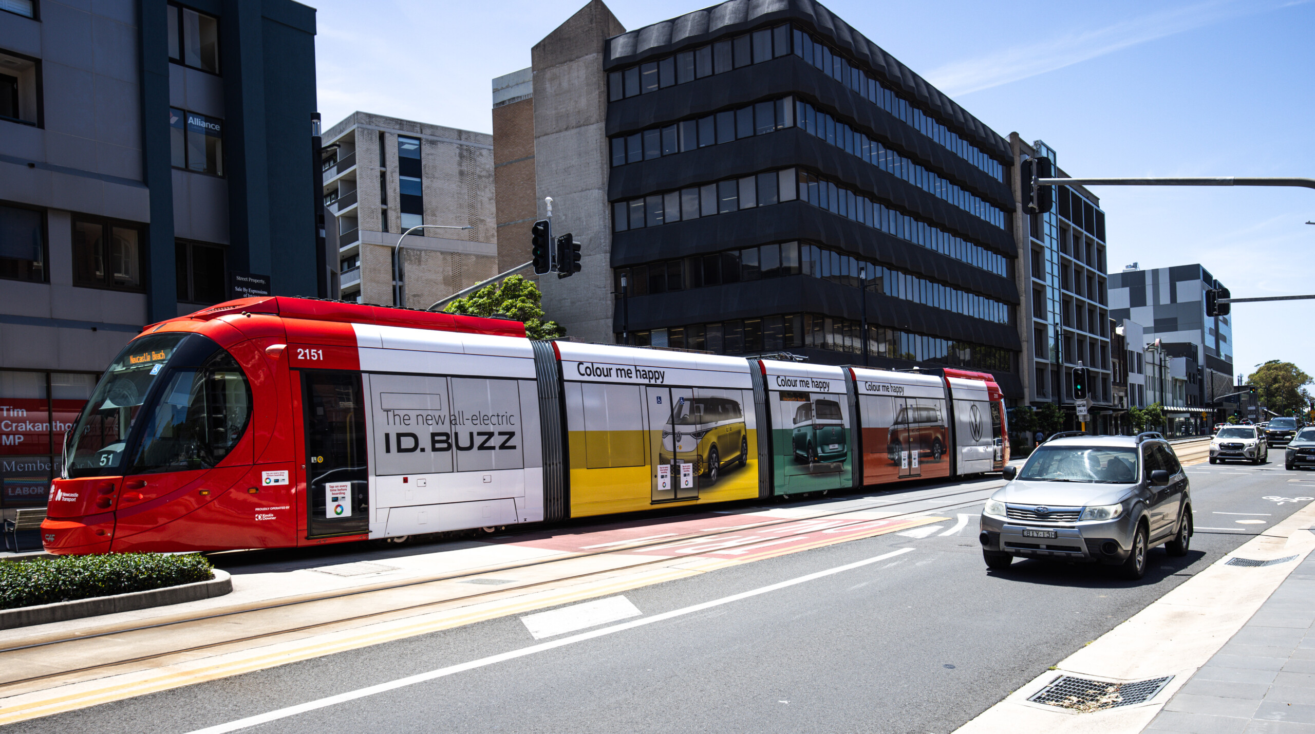 Light rail advertising featuring a full wrap for the Volkswagen ID.Buzz on a Newcastle tram travelling through a busy city street.