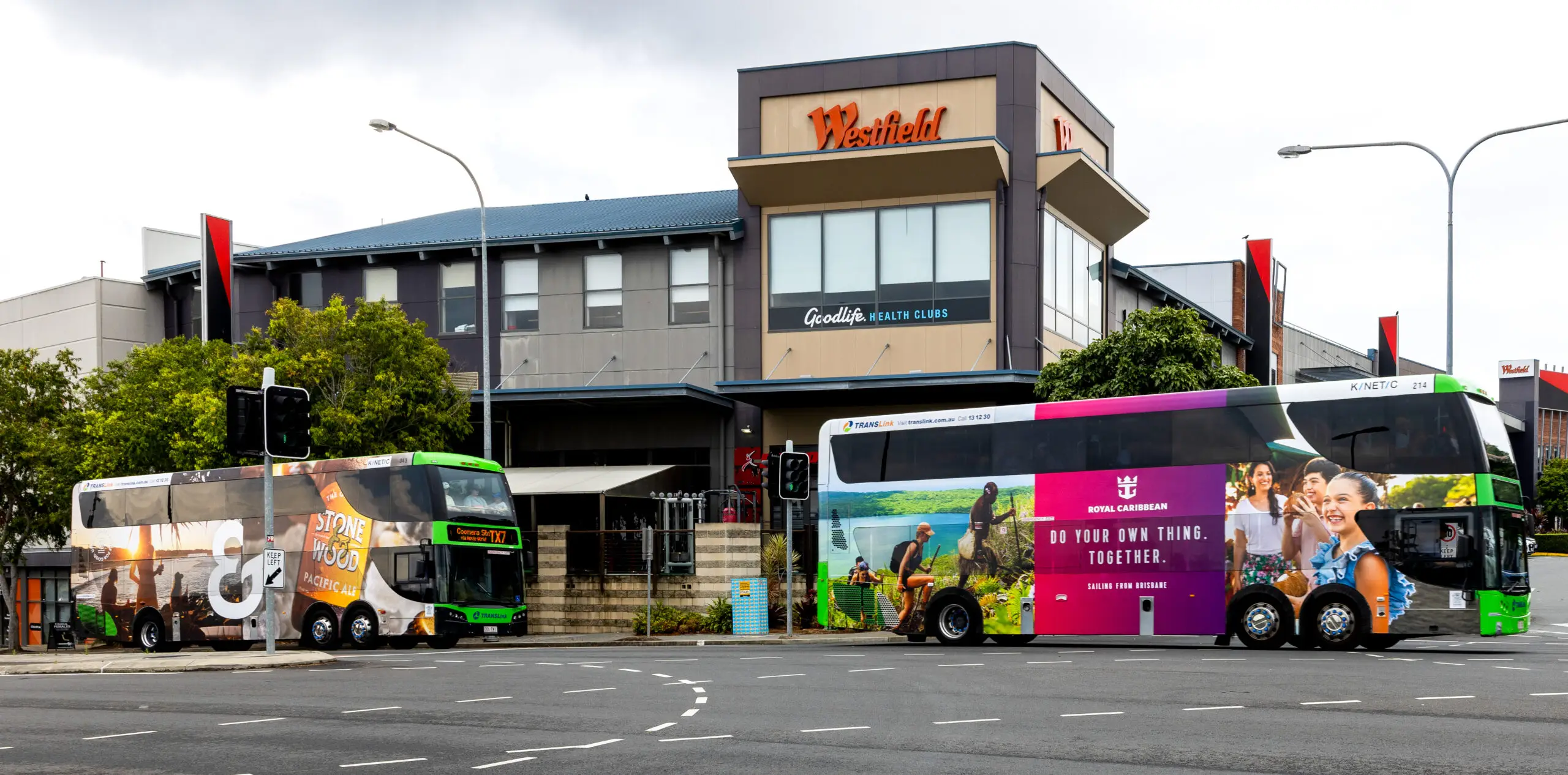 Premium transit advertising displayed on two fully branded double decker buses outside a Westfield shopping centre, showcasing high-impact outdoor media in a busy retail precinct.