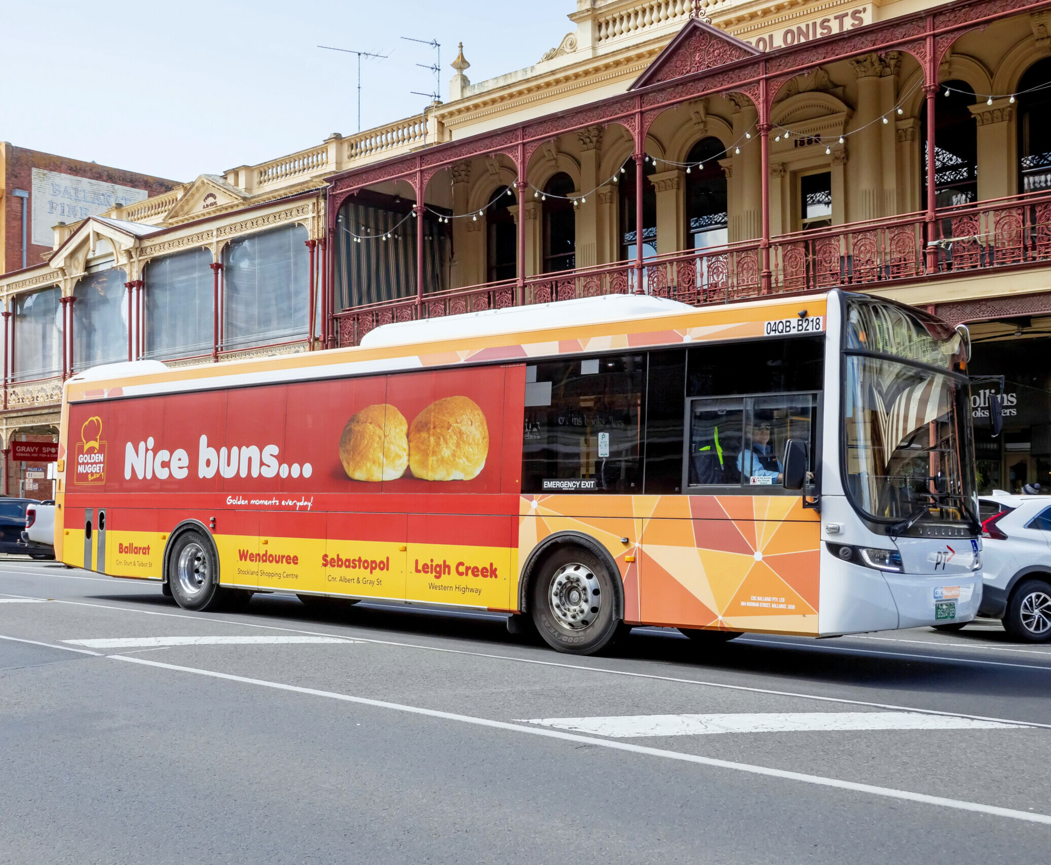 Bus advertising displayed on a regional transit bus operating through a busy town centre in Victoria.